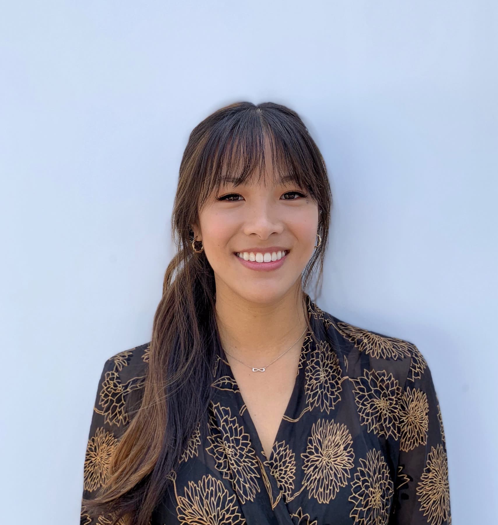 Annie smiling in a floral blouse
