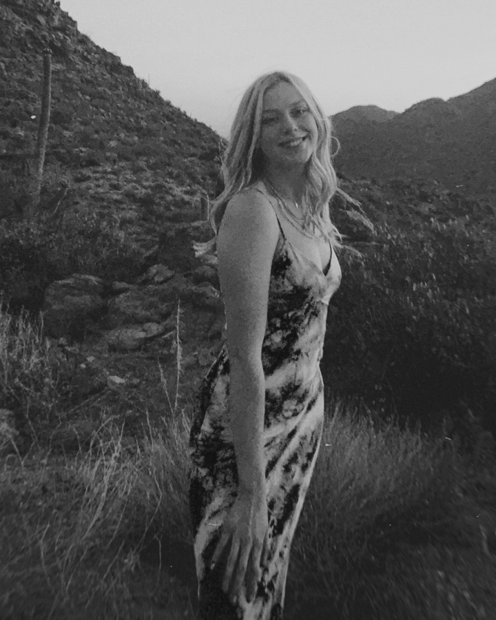Crew member on a desert hillside at dusk, black and white