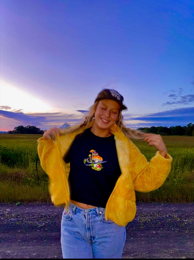 Crew member in a yellow jacket under a sunset sky
