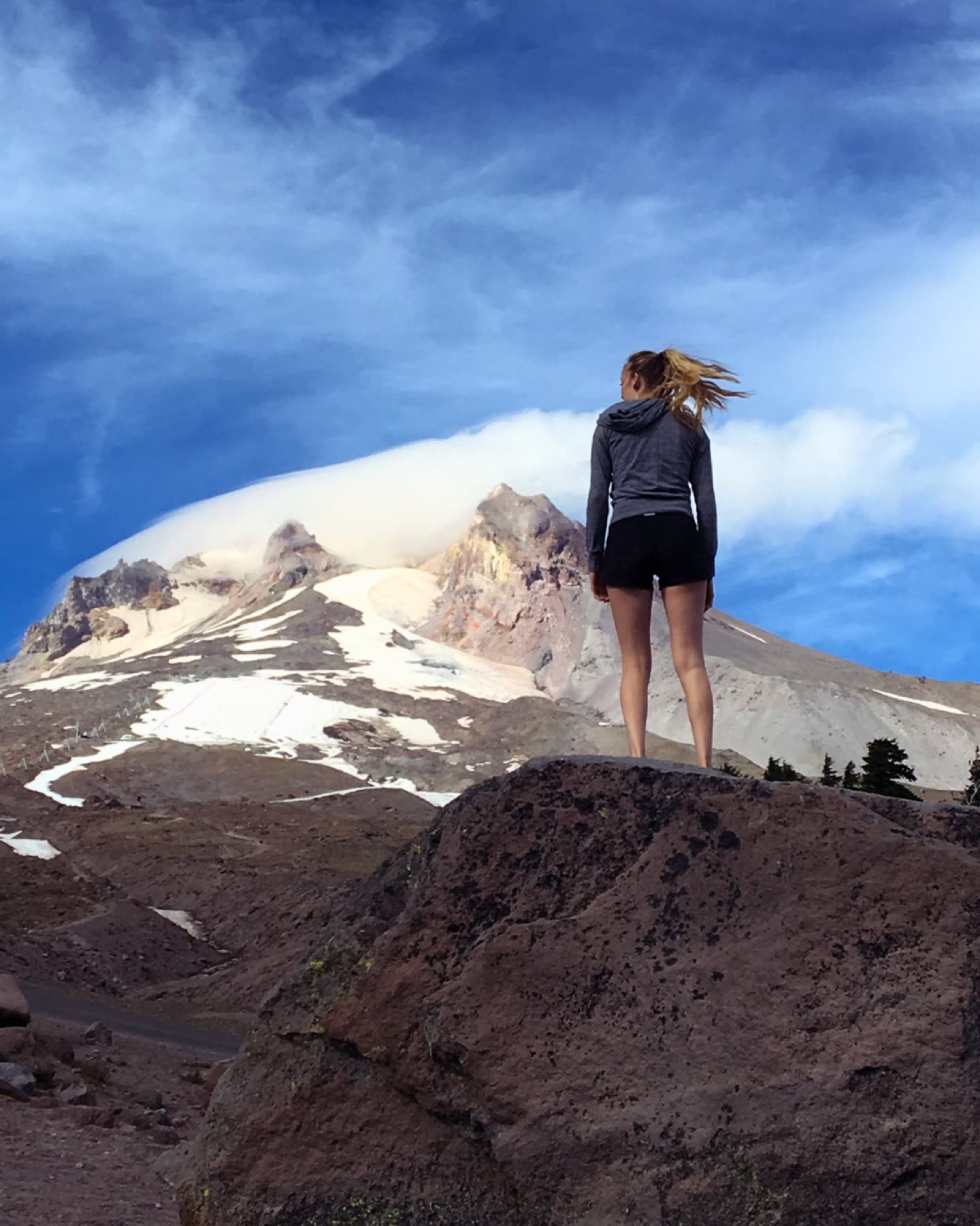 Malia standing on a rock below a snow-capped peak